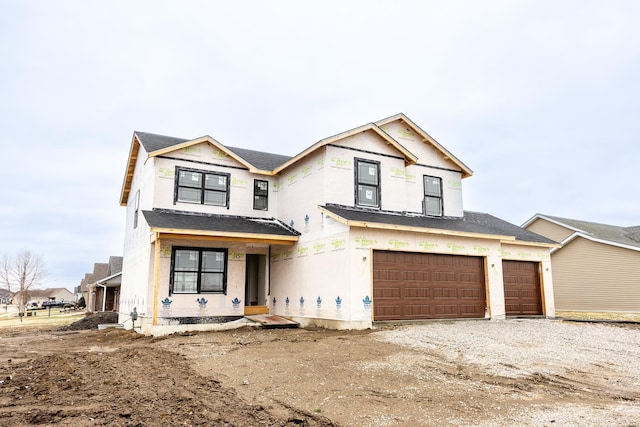 view of front facade featuring a garage and gravel driveway