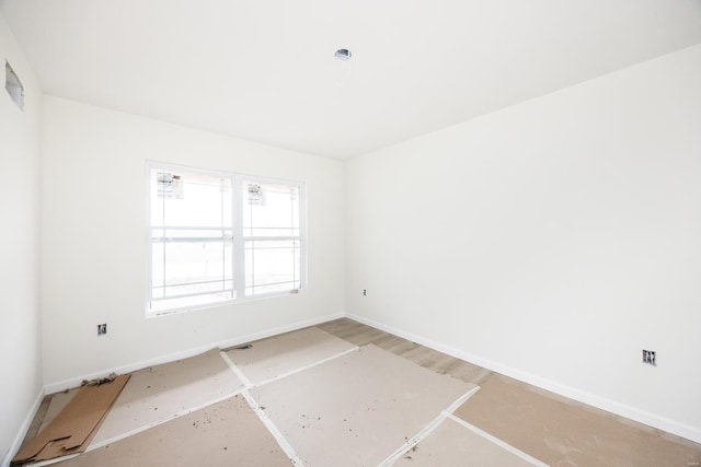 spare room with baseboards