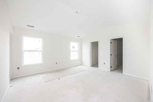 unfurnished bedroom with lofted ceiling and visible vents