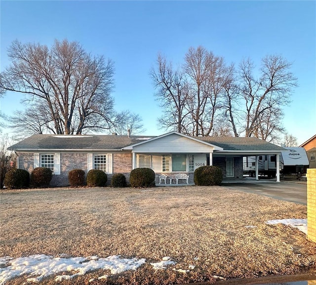 ranch-style house featuring a carport, stone siding, and driveway