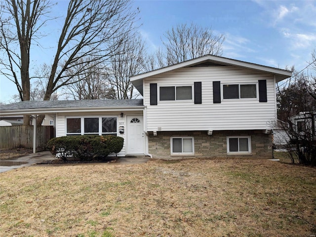 split level home featuring fence and a front yard