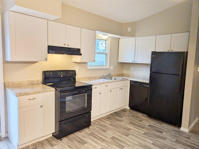 kitchen featuring under cabinet range hood, a sink, white cabinets, light countertops, and black appliances