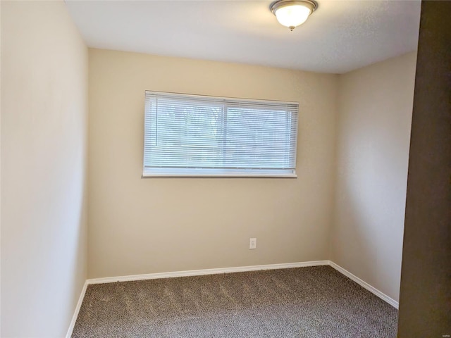 empty room featuring carpet and baseboards