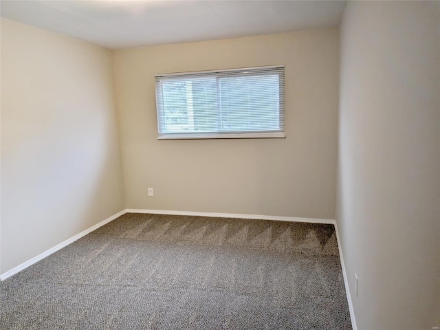 carpeted empty room featuring baseboards