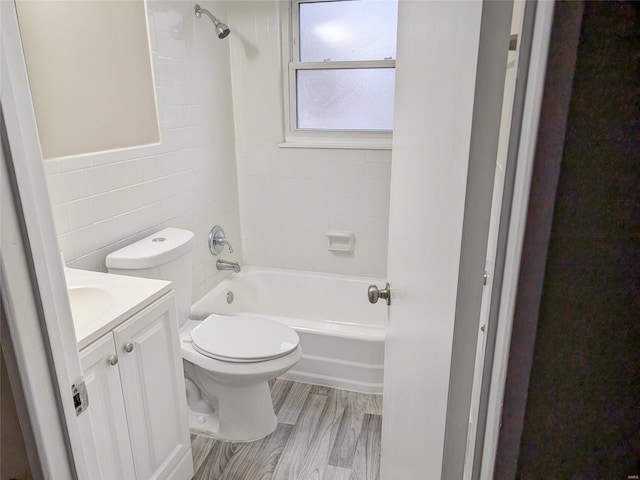 full bathroom with tile walls, toilet, tub / shower combination, vanity, and wood finished floors