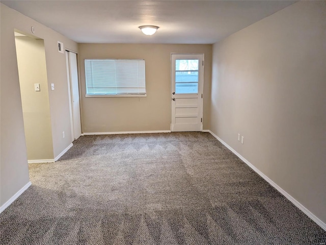 unfurnished room featuring carpet, visible vents, and baseboards