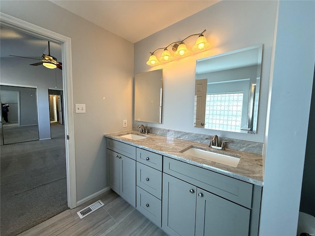 bathroom featuring ceiling fan, double vanity, a sink, and visible vents