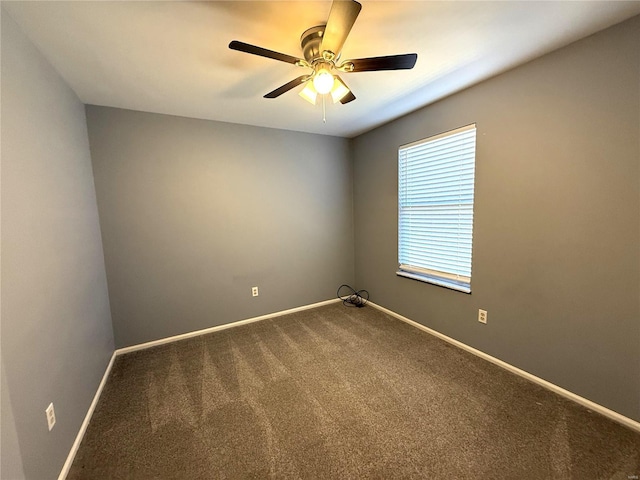 carpeted empty room with ceiling fan and baseboards