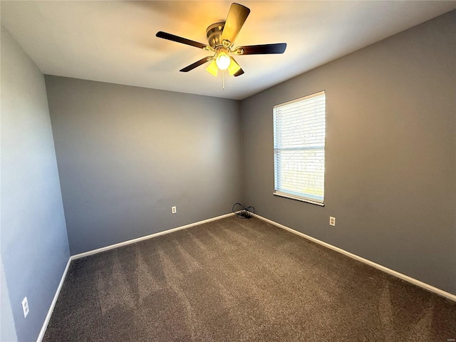 spare room featuring ceiling fan, baseboards, and dark colored carpet