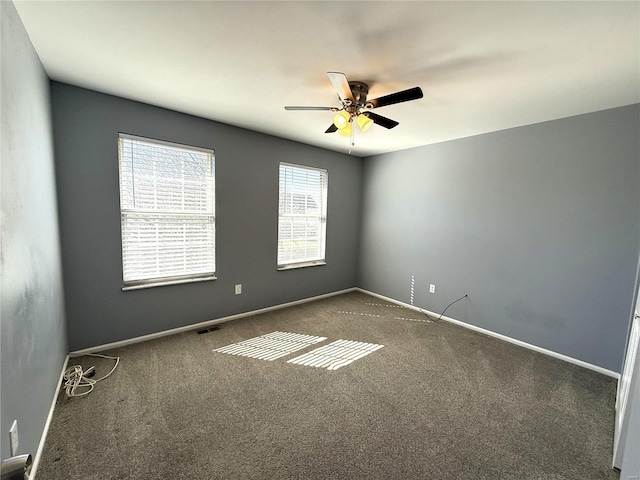 empty room with ceiling fan, carpet, visible vents, and baseboards