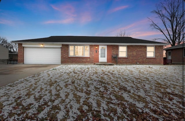 ranch-style house with a garage, brick siding, concrete driveway, and a shingled roof