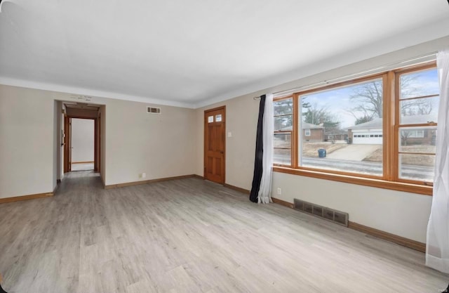 unfurnished room featuring visible vents, baseboards, and light wood-style floors