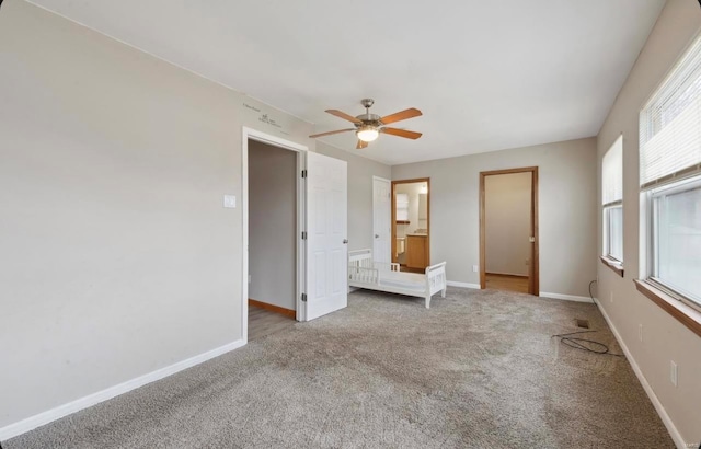 unfurnished bedroom with ceiling fan, baseboards, ensuite bathroom, and carpet flooring