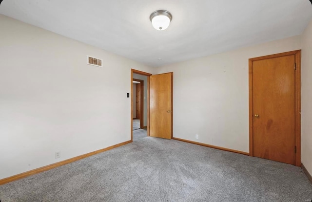 empty room featuring visible vents, baseboards, and carpet floors