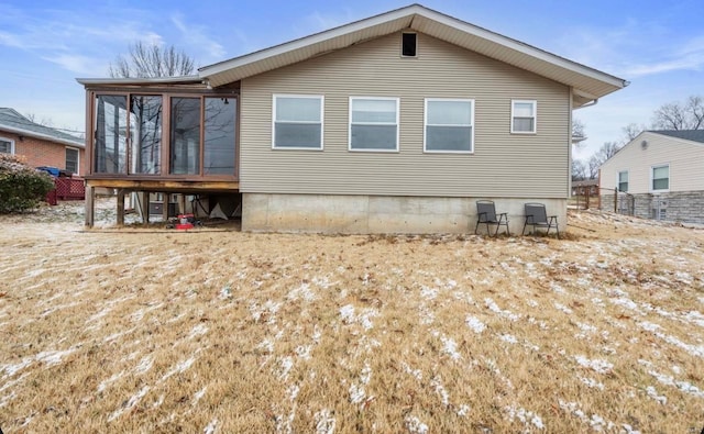 rear view of house featuring fence and a sunroom