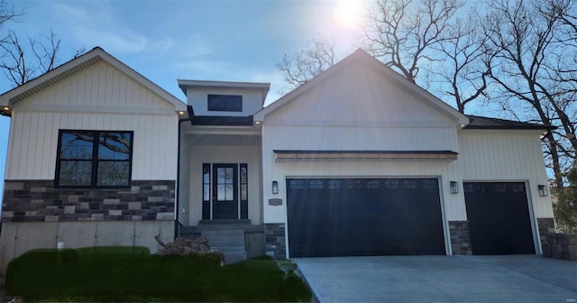 view of front of home featuring stone siding, driveway, and an attached garage