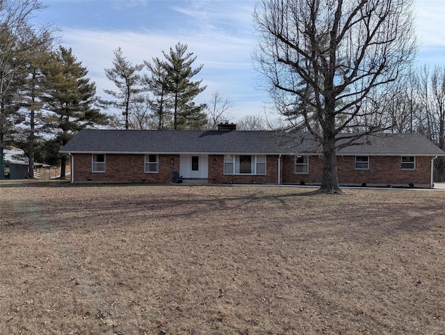 single story home with brick siding, a chimney, and a front lawn