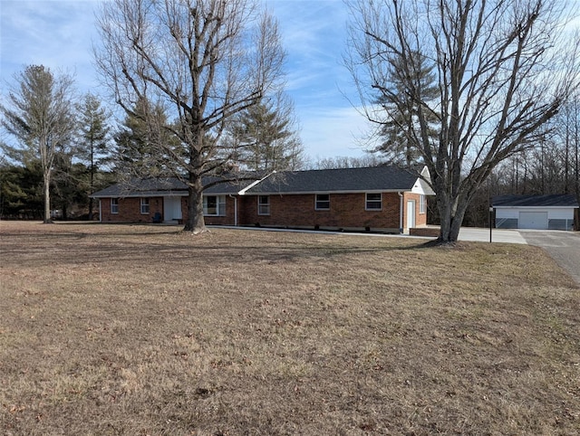 ranch-style house featuring brick siding, a front lawn, and a detached garage