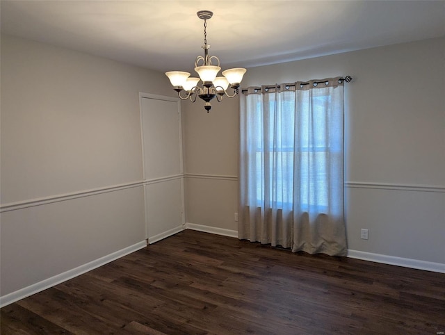 unfurnished room with baseboards, a chandelier, and dark wood-style flooring