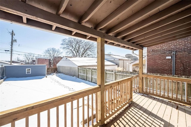 wooden deck with an outdoor structure and a fenced backyard