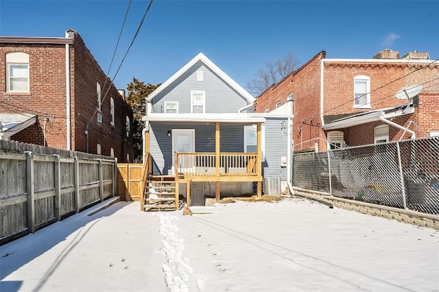 back of property featuring covered porch and a fenced backyard