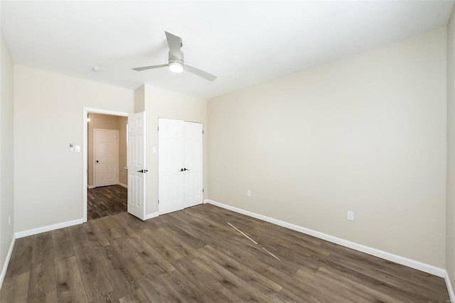 unfurnished bedroom featuring a closet, wood finished floors, a ceiling fan, and baseboards