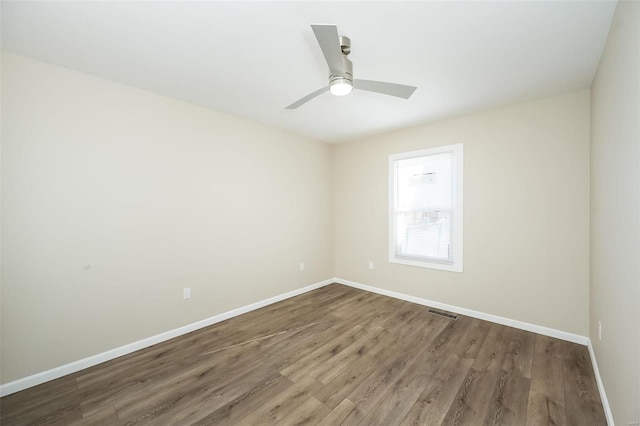 empty room with visible vents, baseboards, ceiling fan, and wood finished floors