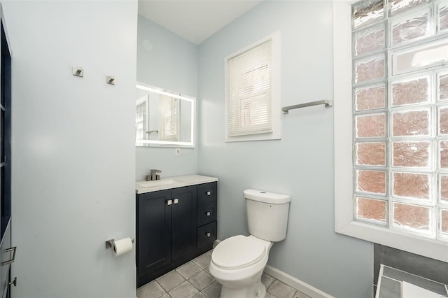 bathroom with baseboards, vanity, toilet, and tile patterned floors