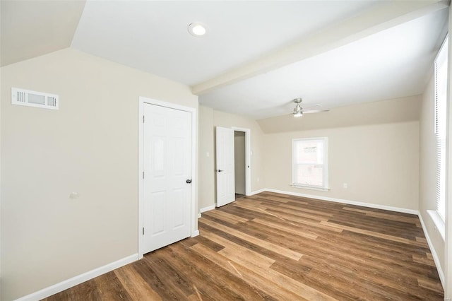 empty room featuring visible vents, vaulted ceiling with beams, baseboards, and wood finished floors