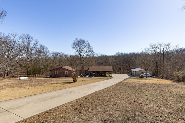 exterior space with concrete driveway and a wooded view