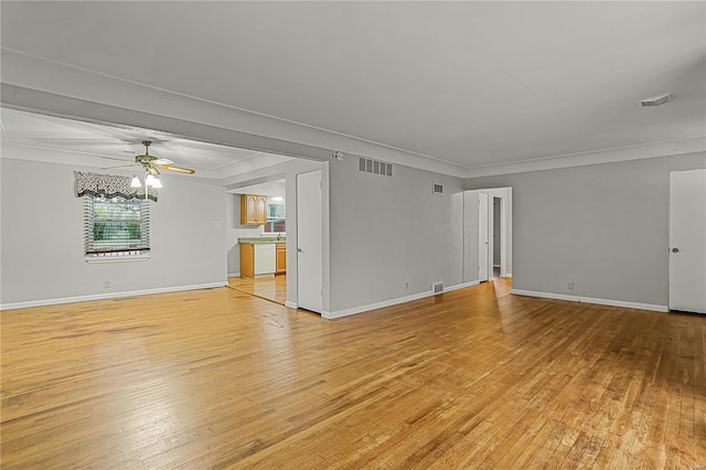 unfurnished living room featuring ceiling fan, light wood-type flooring, visible vents, and crown molding