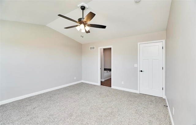 unfurnished bedroom with baseboards, visible vents, ceiling fan, vaulted ceiling, and carpet flooring