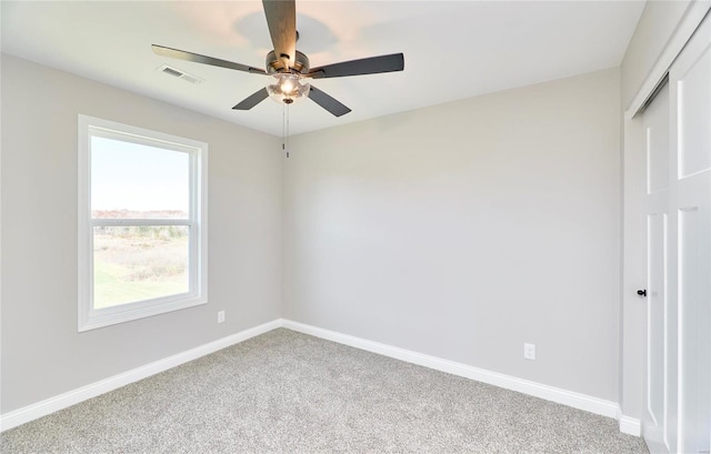 unfurnished bedroom with baseboards, visible vents, a ceiling fan, and light colored carpet