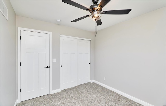 unfurnished bedroom featuring a closet, visible vents, light carpet, and baseboards