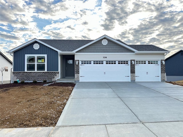 view of front of house featuring concrete driveway, brick siding, board and batten siding, and an attached garage