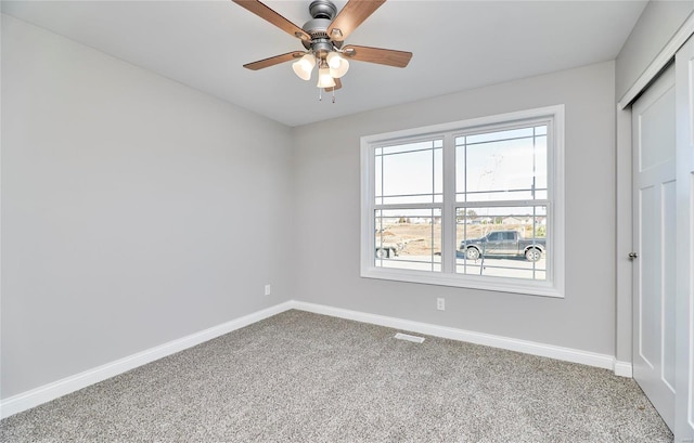 unfurnished bedroom featuring ceiling fan, carpet flooring, visible vents, baseboards, and a closet