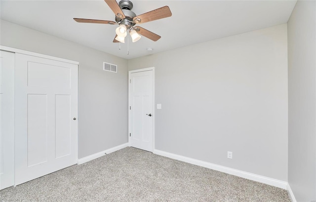 spare room with light carpet, ceiling fan, visible vents, and baseboards