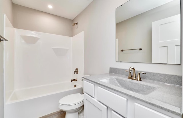 bathroom featuring toilet, shower / bathing tub combination, and vanity