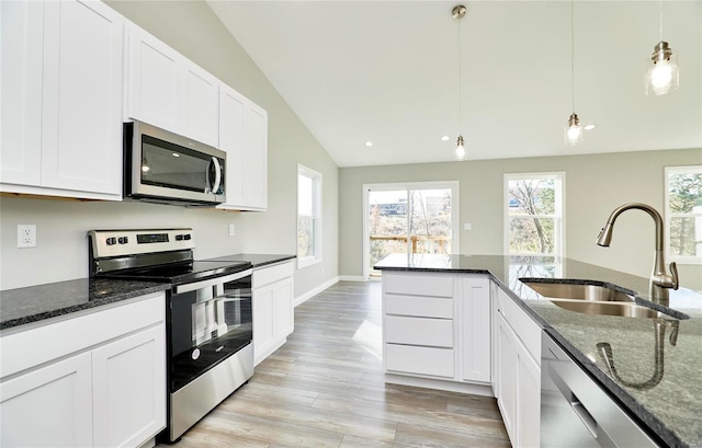 kitchen with stainless steel appliances, pendant lighting, white cabinets, and a sink