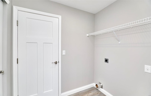 laundry area featuring laundry area, hookup for an electric dryer, baseboards, and wood finished floors