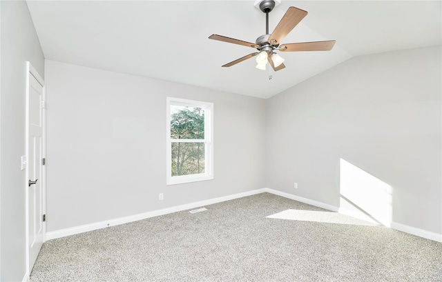 carpeted empty room with lofted ceiling, baseboards, and a ceiling fan