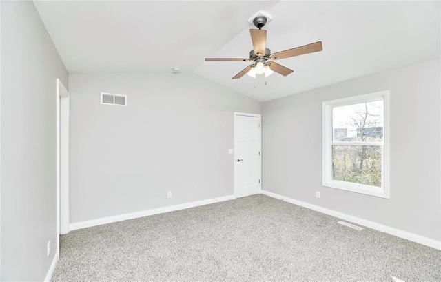 unfurnished room with lofted ceiling, carpet, visible vents, and baseboards