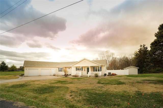 view of front of house with driveway, covered porch, a garage, and a front yard