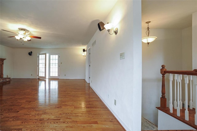 unfurnished living room featuring ceiling fan, visible vents, and wood finished floors