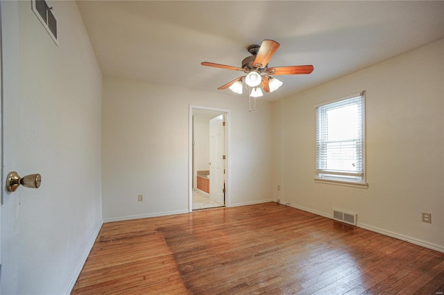 spare room with light wood-style floors, visible vents, baseboards, and a ceiling fan