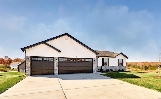 view of front of home with an attached garage, stone siding, a front lawn, and concrete driveway