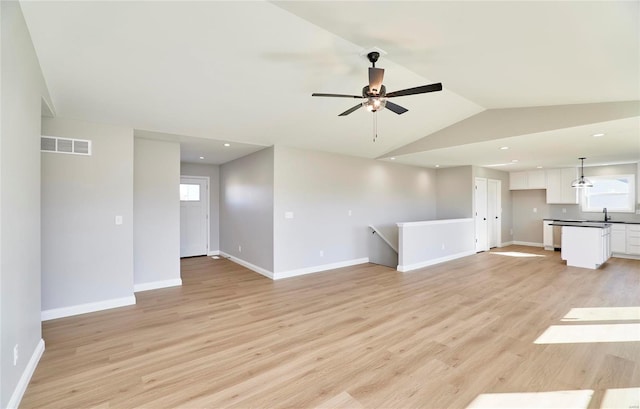 unfurnished living room with baseboards, visible vents, vaulted ceiling, light wood-type flooring, and recessed lighting