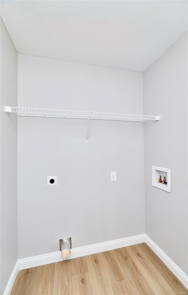 washroom with laundry area, baseboards, light wood-style flooring, hookup for an electric dryer, and washer hookup