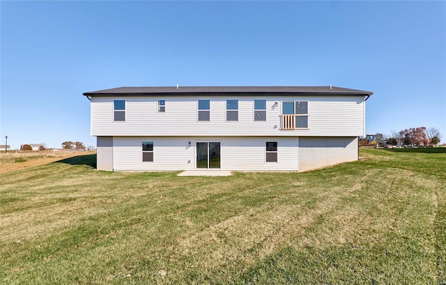 rear view of house featuring a lawn