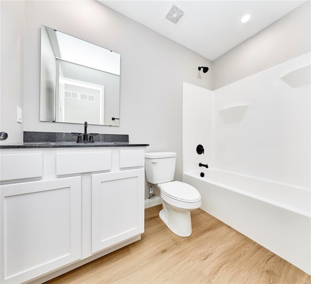 full bath featuring bathtub / shower combination, visible vents, toilet, vanity, and wood finished floors